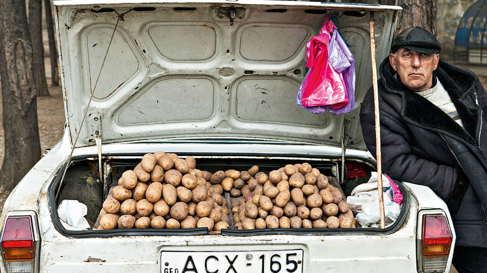 Mitten in Tiflis: Ein Bauer verkauft Kartoffeln aus dem Kofferraum seines Wagens. Ein ganz alltäglicher Anblick in Georgiens Hauptstadt. Etwa 50 Prozent aller Georgier sind in der Landwirtschaft tätig, beackern meist kleine Flächen. Man produziert für den Eigenbedarf, und was man nicht verbraucht, wird getauscht oder verkauft – auf Märkten, in Unterführungen oder eben aus dem Auto. 